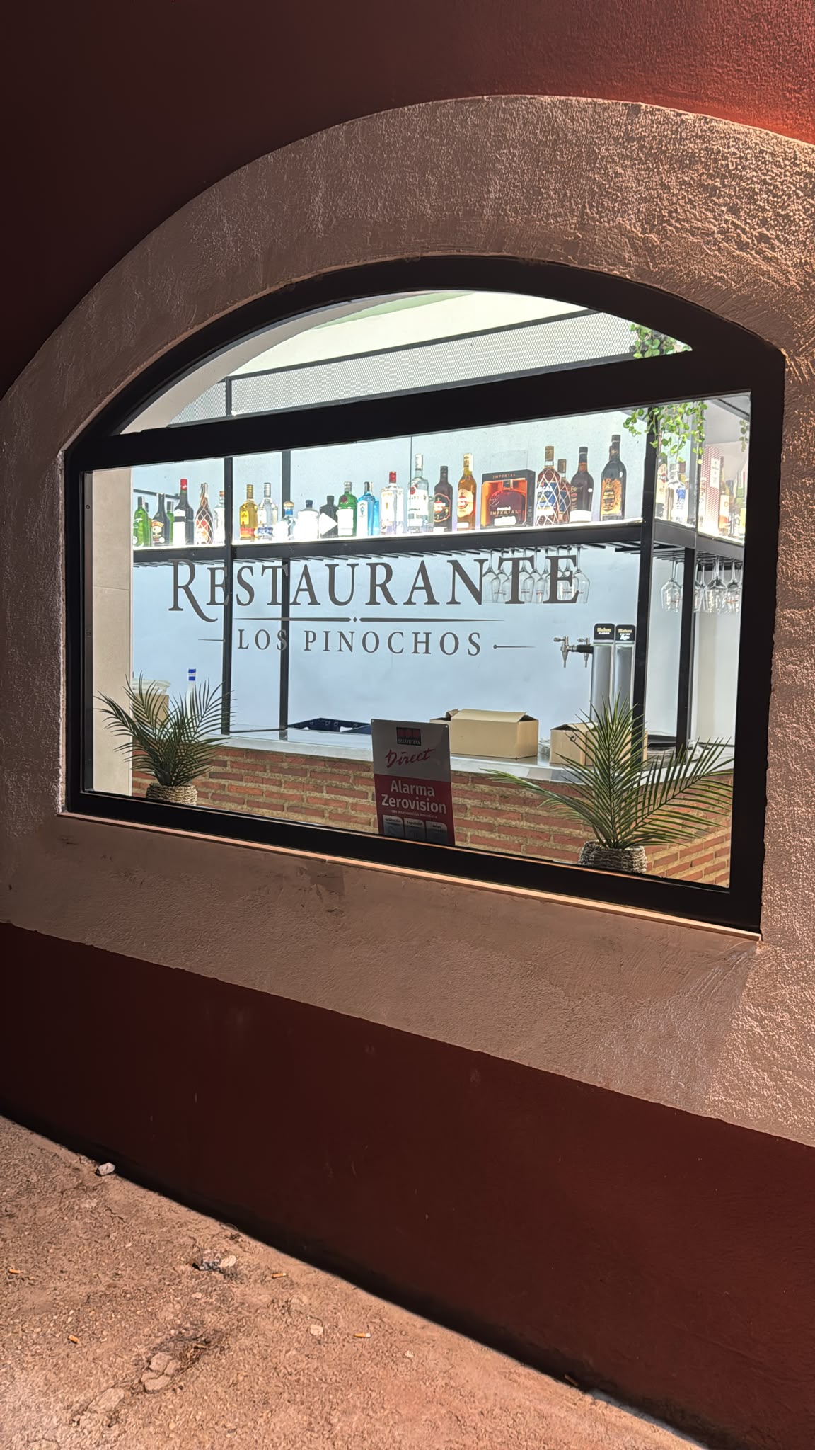 Interior del Restaurante Los Pinochos visto desde la calle a través del arco de la fachada